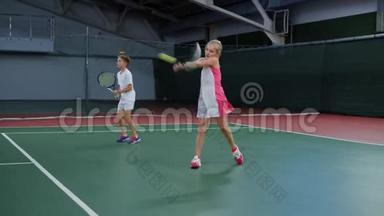 两名年轻运动员在娱乐区<strong>玩体育游戏</strong>。 开心的姐姐和哥哥在网球课上花时间